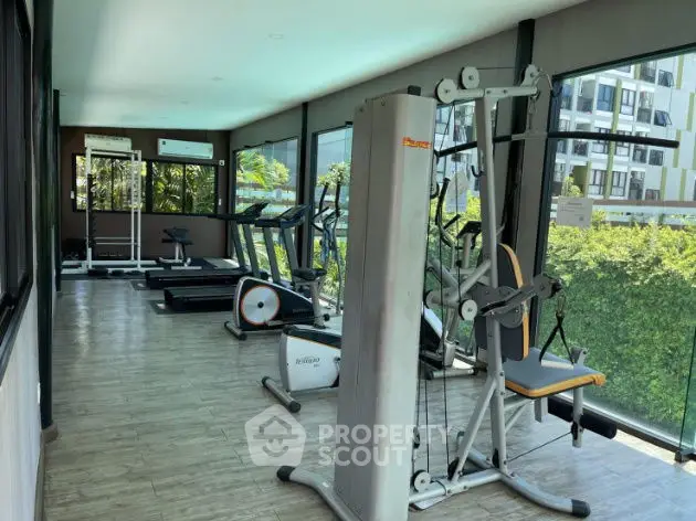 Modern gym with state-of-the-art equipment and scenic views in luxury condominium.
