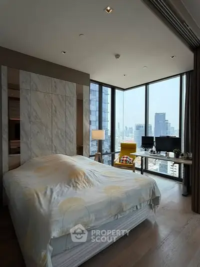 Luxurious bedroom with stunning city view and modern decor in high-rise apartment.