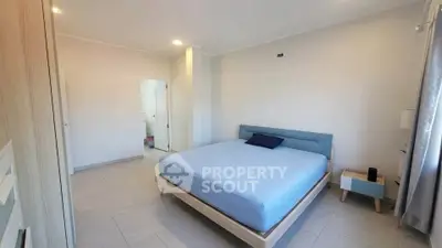 Spacious modern bedroom with minimalist design and natural light.