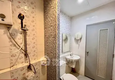 Compact bathroom with shower, sink, and toilet in modern apartment.