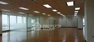 Spacious office space with glass partitions and ample natural light.
