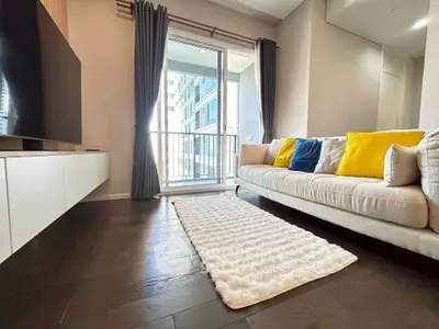 Modern living room with cozy sofa, stylish decor, and balcony view in urban apartment.