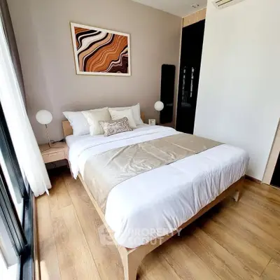 Modern bedroom with stylish decor and natural light, featuring a cozy bed and elegant wooden flooring.