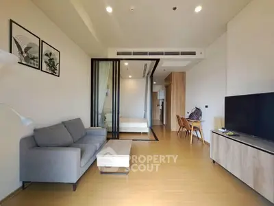 Modern living room with stylish decor and open layout, featuring a cozy sofa and sleek furniture.