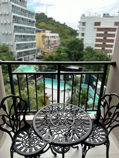 Charming balcony with intricate furniture overlooking lush greenery and pool view.