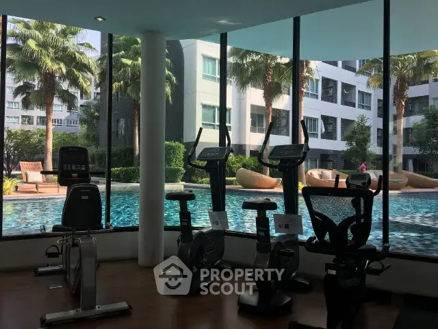 Modern gym with pool view in luxury condominium complex