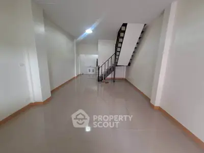 Spacious open-plan interior with sleek staircase and glossy tiled flooring, ideal for modern living.