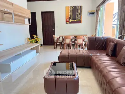Spacious living room with modern leather sofa and elegant dining area, perfect for stylish living.