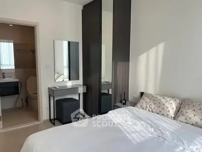 Modern bedroom with ensuite bathroom, featuring sleek furniture and natural light.