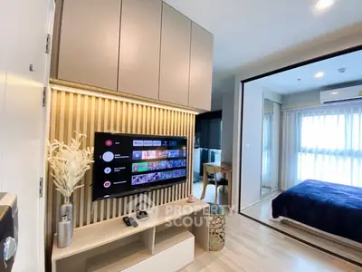 Modern living room with wall-mounted TV and view into cozy bedroom