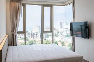 Modern bedroom with panoramic city view and wall-mounted TV