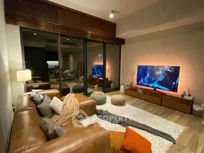 Luxurious living room with leather sofa, large TV, and cozy decor for ultimate relaxation.
