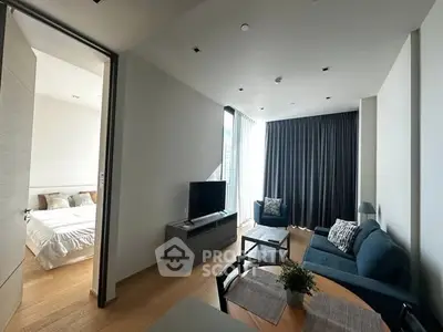 Modern living room with cozy seating and natural light, adjacent to a stylish bedroom.