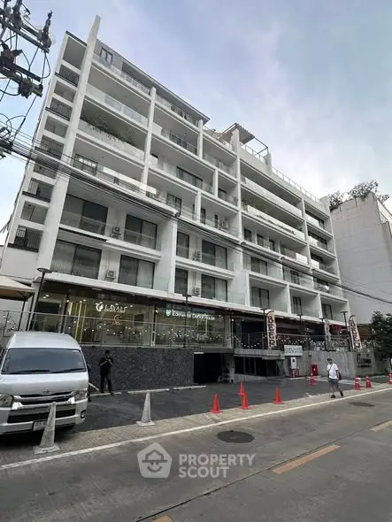 Modern multi-story building with commercial spaces on ground floor, ideal for urban living.