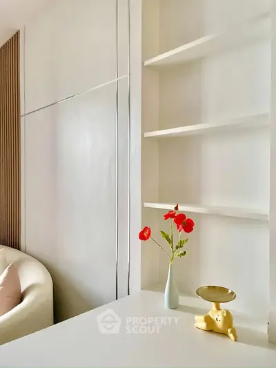 Elegant modern living room with minimalist decor and stylish shelving unit.