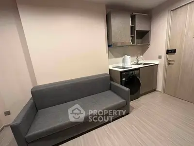 Modern compact living room with kitchenette and sofa in stylish apartment