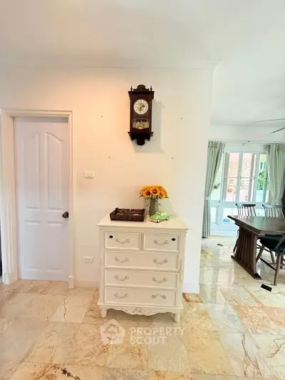 Charming interior with vintage clock and elegant furniture in a bright, airy room.