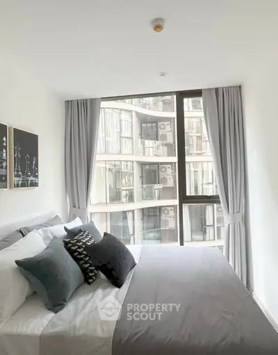 Modern bedroom with large window and stylish decor in urban apartment