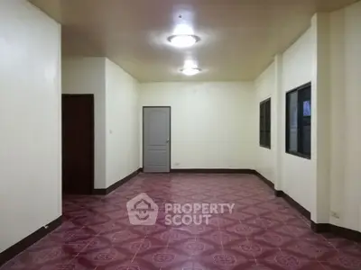 Spacious empty room with tiled floor and bright lighting, ideal for customization.