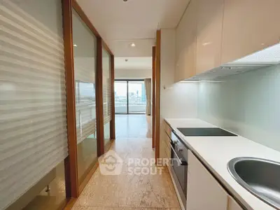 Modern kitchen with sleek design and open layout leading to a bright living area with city views.