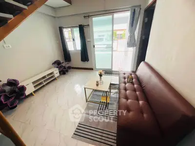 Cozy living room with modern decor and sliding glass doors leading to a spacious balcony.