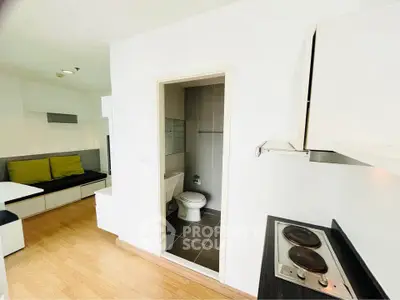 Modern compact apartment with open kitchen and bathroom view, featuring sleek design and efficient layout.