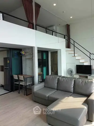 Modern loft-style living room with high ceilings and sleek furniture