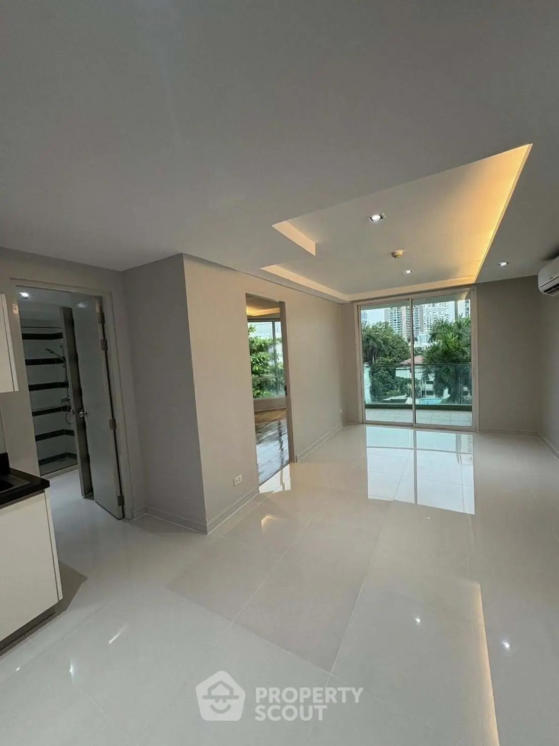 Spacious modern living room with large windows and glossy floors, offering a bright and airy ambiance.