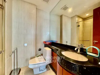 Modern bathroom with sleek fixtures and elegant design, featuring a spacious shower and stylish vanity.