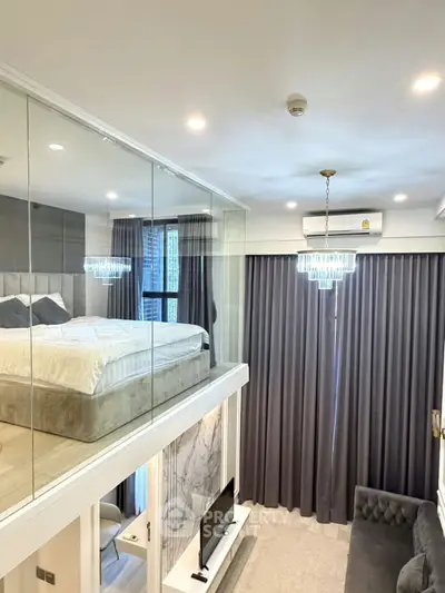 Luxurious modern loft with glass-walled bedroom and elegant living area featuring a chic chandelier.