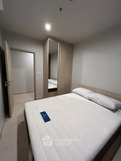 Cozy bedroom with modern wardrobe and comfortable bed in stylish apartment.