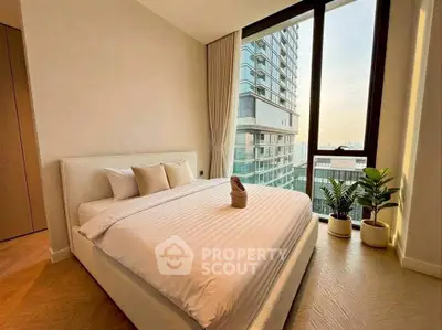 Luxurious bedroom with stunning city view and elegant decor in modern high-rise apartment.