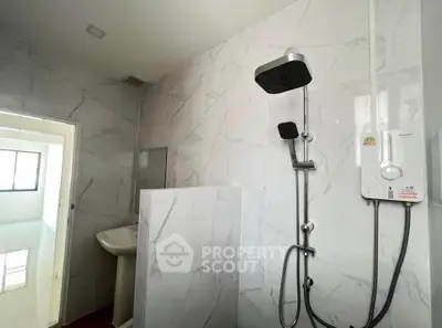 Modern bathroom with sleek shower and marble tiles in a stylish apartment.