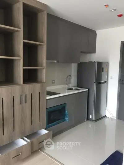 Modern kitchen with sleek cabinetry and stainless steel appliances in a contemporary apartment.