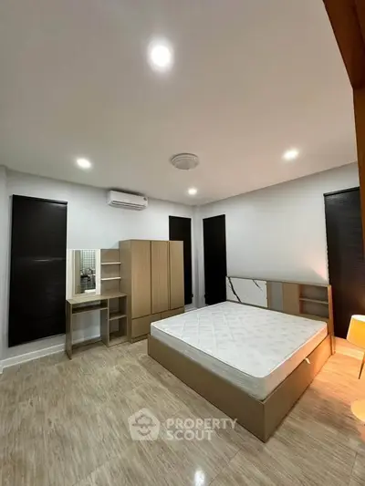 Spacious modern bedroom with minimalist design and ample natural light.