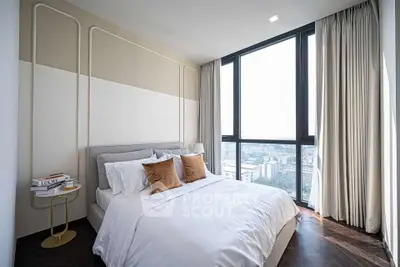 Luxurious bedroom with floor-to-ceiling windows offering stunning city views, elegant decor, and plush bedding.