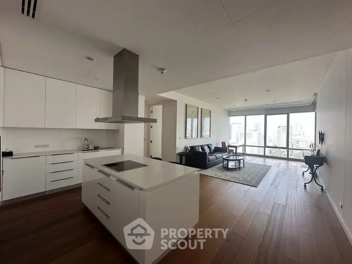 Spacious modern apartment with open kitchen and city view, featuring sleek design and ample natural light.
