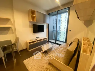 Modern living room with sleek furniture and large window in a high-rise apartment.