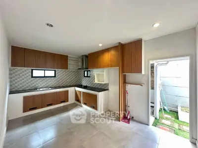 Modern kitchen with sleek cabinetry and open layout, featuring ample natural light and tiled flooring.