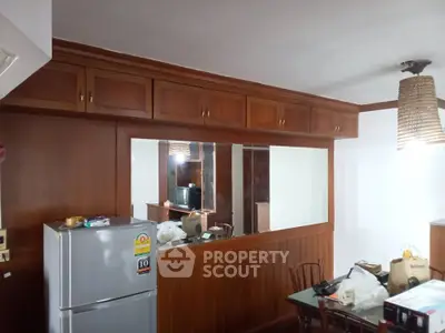 Charming kitchen with wooden cabinets and dining area in cozy apartment