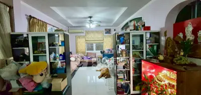 Spacious living room with modern decor and ample natural light, featuring stylish shelving and cozy seating area.