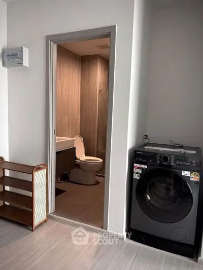 Modern apartment with bathroom and washing machine, featuring sleek design and efficient use of space.