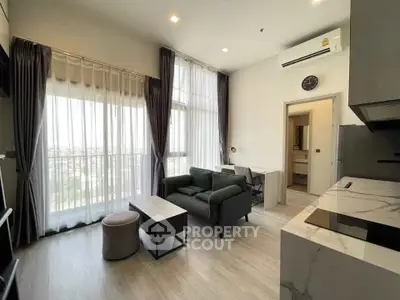Modern living room with high ceilings and large windows offering a bright, airy ambiance.