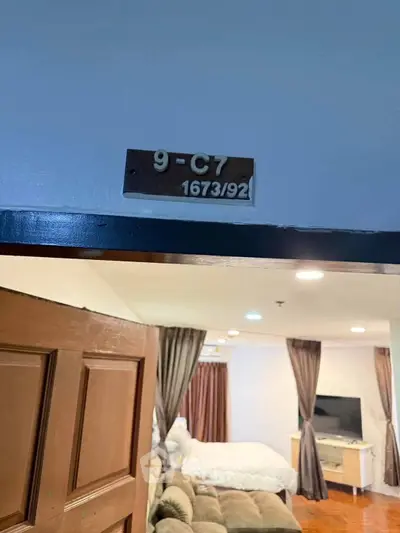 Spacious living room with cozy seating and modern decor in a well-lit apartment.