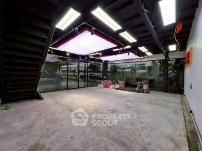 Spacious commercial space with modern lighting and large windows, ideal for retail or office use.