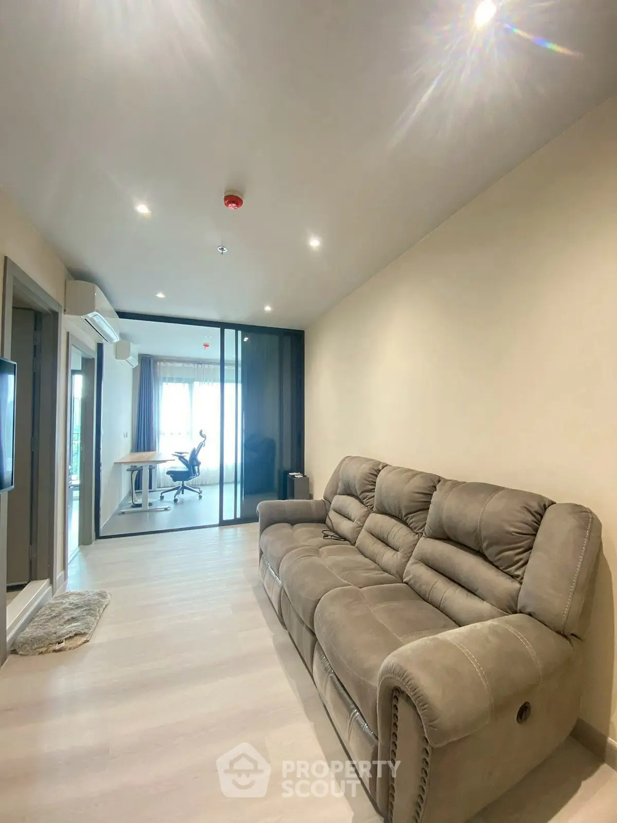 Modern living room with plush sofa and study area in open layout apartment