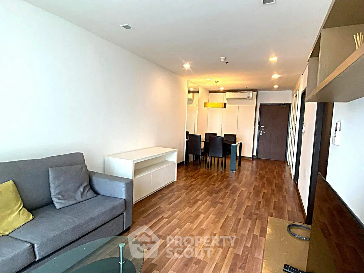 Spacious modern living room with wooden flooring and stylish furniture in a contemporary apartment.