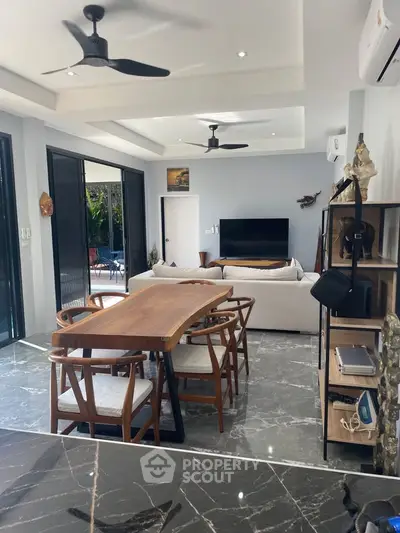 Modern living room with stylish furniture and open layout, featuring a sleek dining area and cozy seating.