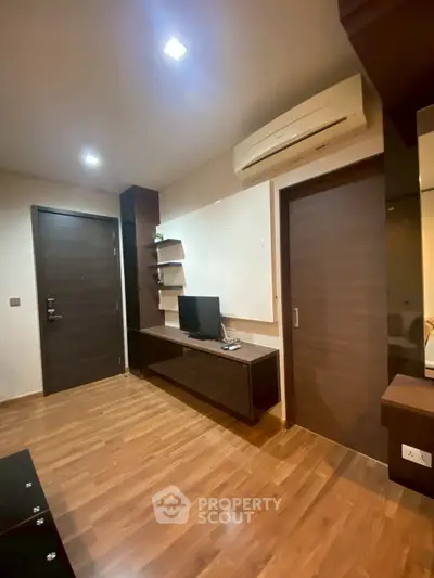 Modern living room with wooden flooring and sleek furniture design.