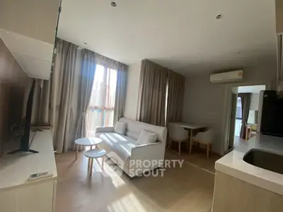 Modern living room with natural light and cozy furniture in a stylish apartment.